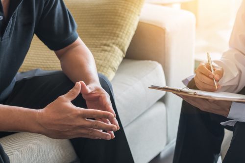 Professionelle Beratungsstellen für Unterstützung bei Glücksspielproblemen Beratungsgespräch zwischen zwei Personen, bei dem Notizen auf einem Klemmbrett gemacht werden